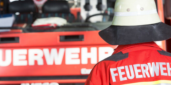 Feuerwehrmann vor einem Feuerwehrfahrzeug. Quelle: Tom Bilger