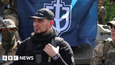 Denis Kapustin (centre) flanked by Russian Volunteer Corps fighters talk to reporters in Ukraine. Photo: 24 May 2023