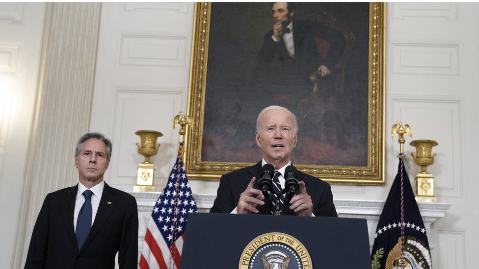 Biden im dunklen Anzug auf dem Podium vor dem Porträt von Abraham Lincoln, rechts von ihm Blinken im dunklen Anzug und mit blauer Krawatte.