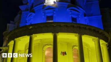 Government buildings lit up in blue and yellow