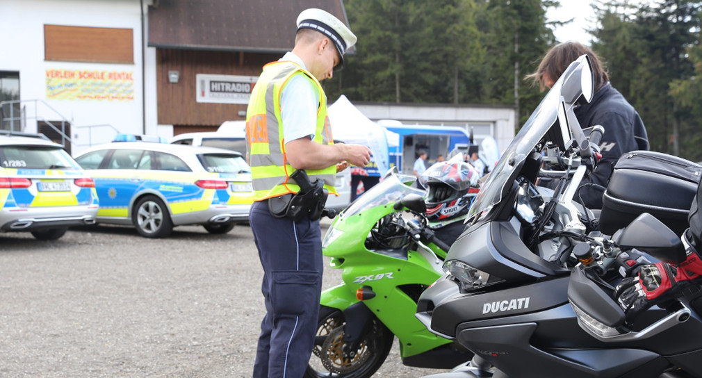 Ein Polizist kontrolliert einen Motorradfahrer.