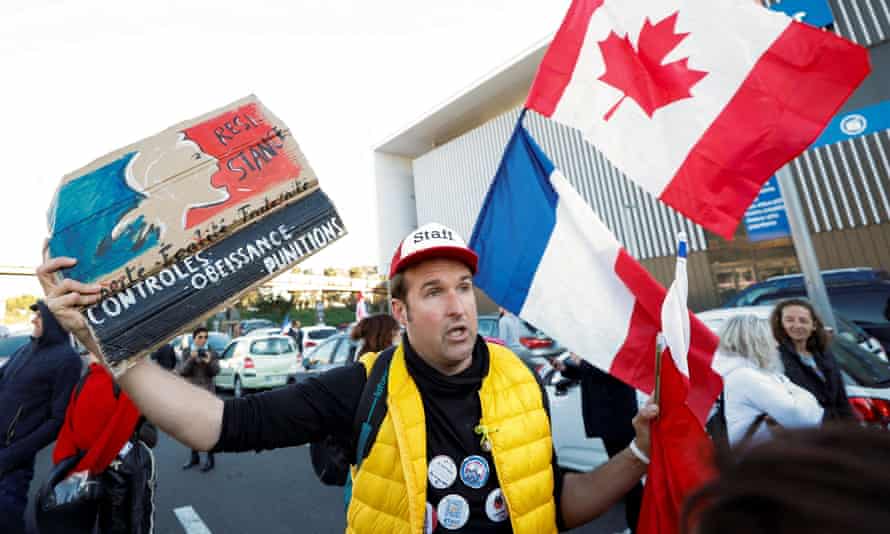 Ein Demonstrant in Nizza mit französischer und kanadischer Flagge 