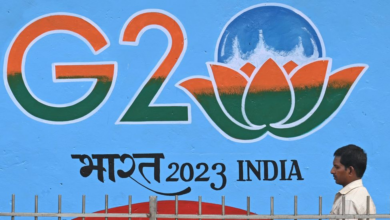 Ein Mann geht in Neu-Delhi an einem Schild vorbei, das für den G20-Gipfel wirbt