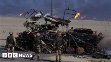 US troops surround a destroyed tank in Iraq War of 2003