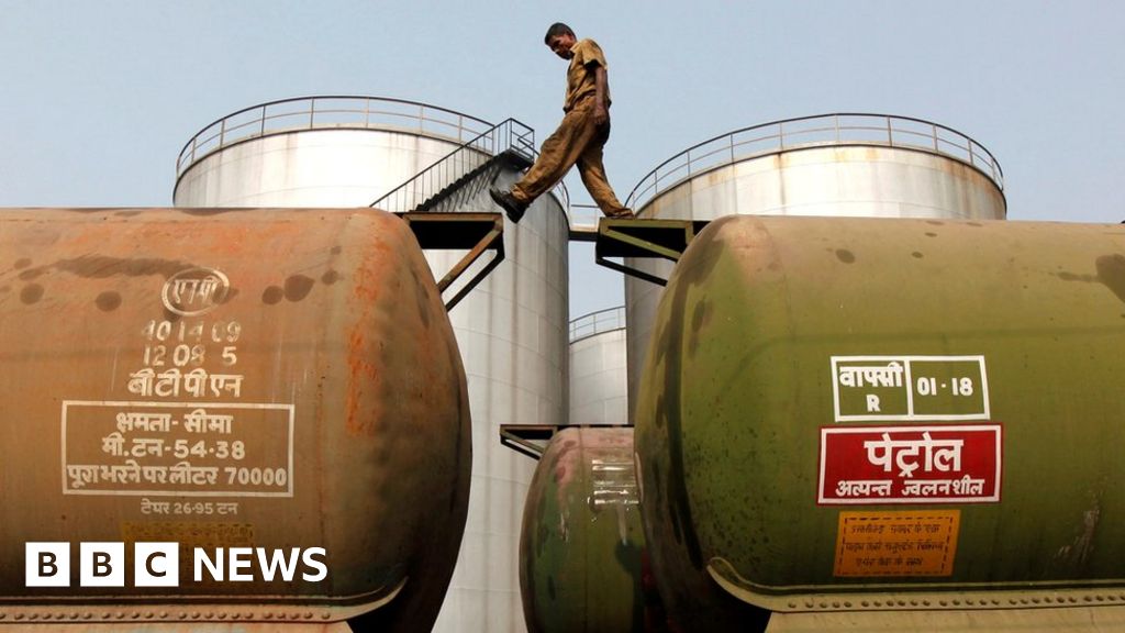 A worker walks atop a tanker wagon at an oil terminal near Kolkata.
