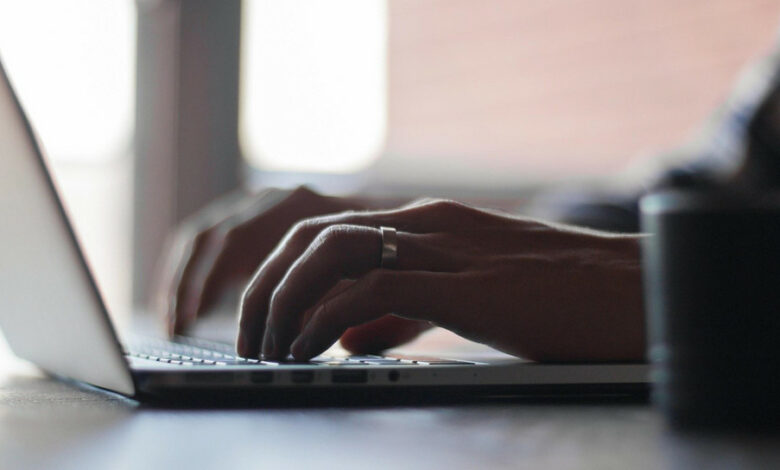 Eine Person schreibt auf der tastatur eines Laptops