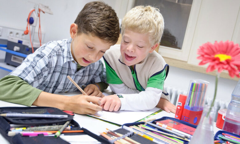 Die Schüler Johannes (l.) und Felix (r.), ein Junge mit Down-Syndrom, sitzen in der Gemeinschaftsschule Gebhardschule in Konstanz an einem Klassentisch beim Malen. (Foto: © dpa)