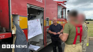 Blurred image op-sec'd (approved for use by MOD) of three Ukrainian military personnel training at RAF Wittering on specialised fire engines