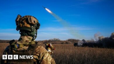 A Ukrainian soldier watches a rocket launcher firing towards Russian positions on the front line in eastern Ukraine in November