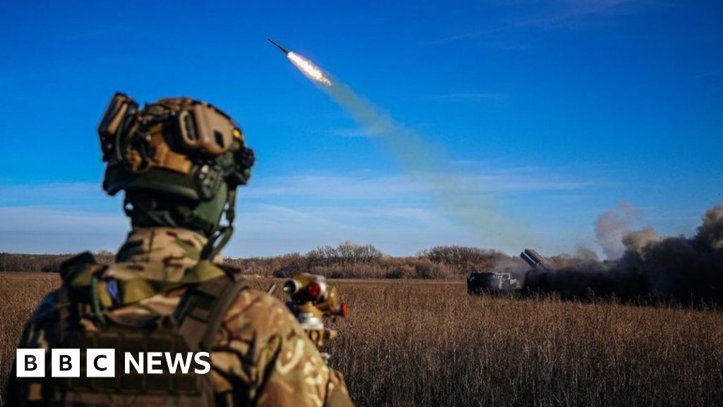 A Ukrainian soldier watches a rocket launcher firing towards Russian positions on the front line in eastern Ukraine in November