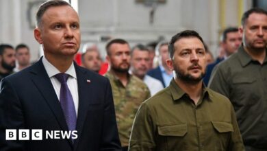 Ukraine's President Volodymyr Zelensky and his Polish counterpart Andrzej Duda (L) lay candles during service in Lutsk cathedral, 9 Jul 23