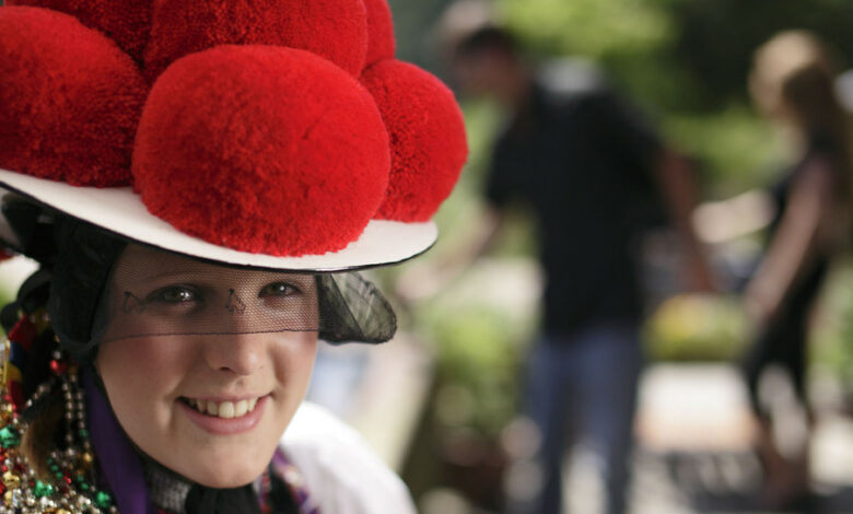 Eine junge Frau trägt einen traditionellen Bollenhut.