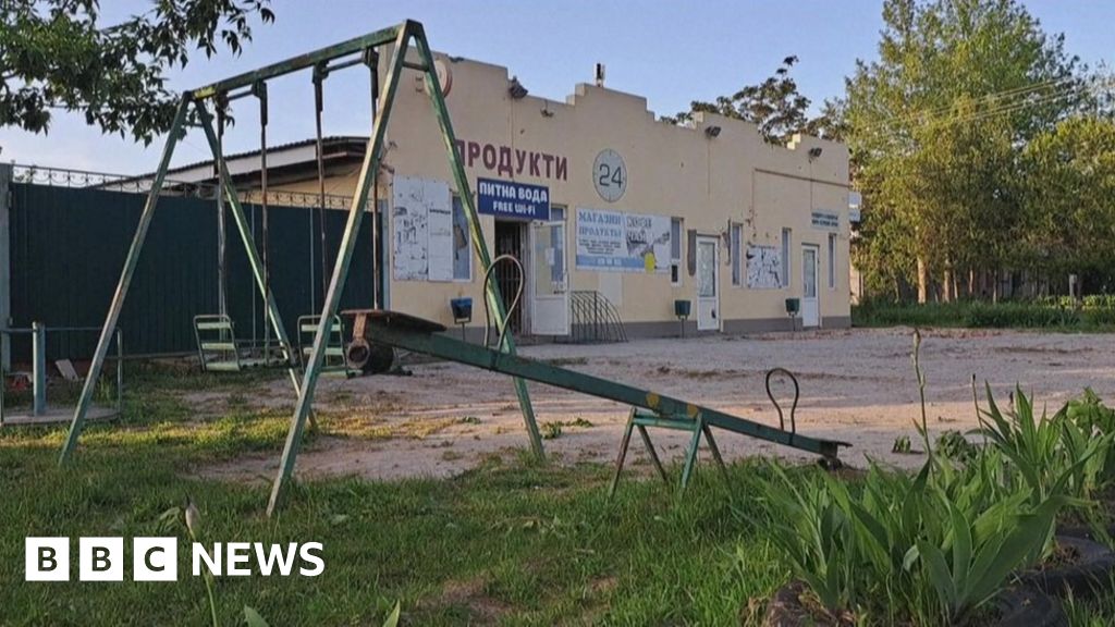 Damaged shop in Zelenivka, with a children's play area in front