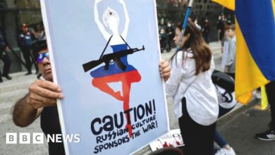 A protester in Mexico City holds a sign reading, Caution! Russian culture sponsors the war!