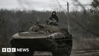 Ukrainian servicemen on a BMP-2 tank drive towards Bakhmut on 11 March