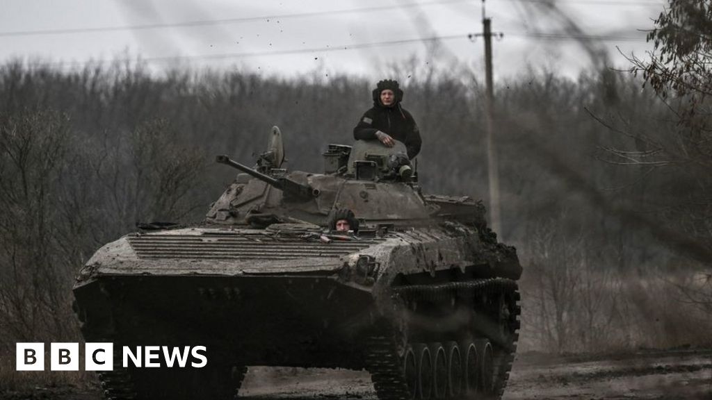 Ukrainian servicemen on a BMP-2 tank drive towards Bakhmut on 11 March