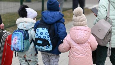 Drei Kinder kommen an einer Grenze an