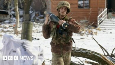 A soldier carrying a mortar shell in Vuhledar