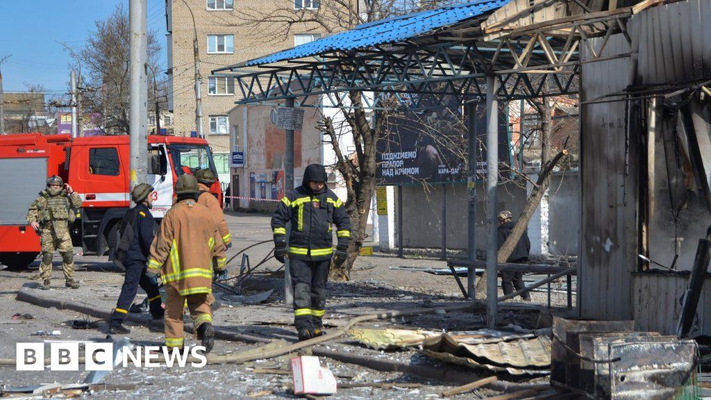 Rescuers work at a bus stop which was hit during a rocket attack in Kherson