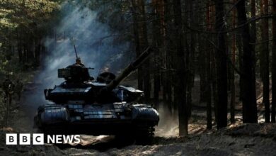 Ukrainian soldiers drive a captured Russian tank in Kupiansk region