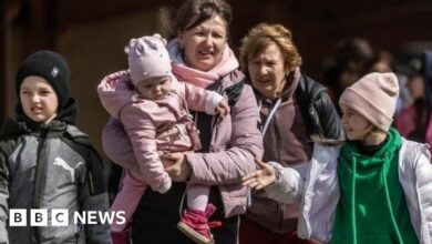 Ukrainian refugees walking on train platform in Poland