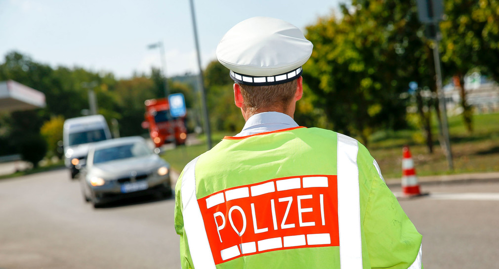Ein Polizist der Polizei Baden-Württemberg regelt den Verkehr.