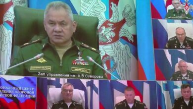 Ein Standbild aus dem Filmmaterial zeigt eine Videoverbindung mit Verteidigungsminister Sergej Schoigu auf einer großen Leinwand und Admiral Sokolow direkt unter ihm
